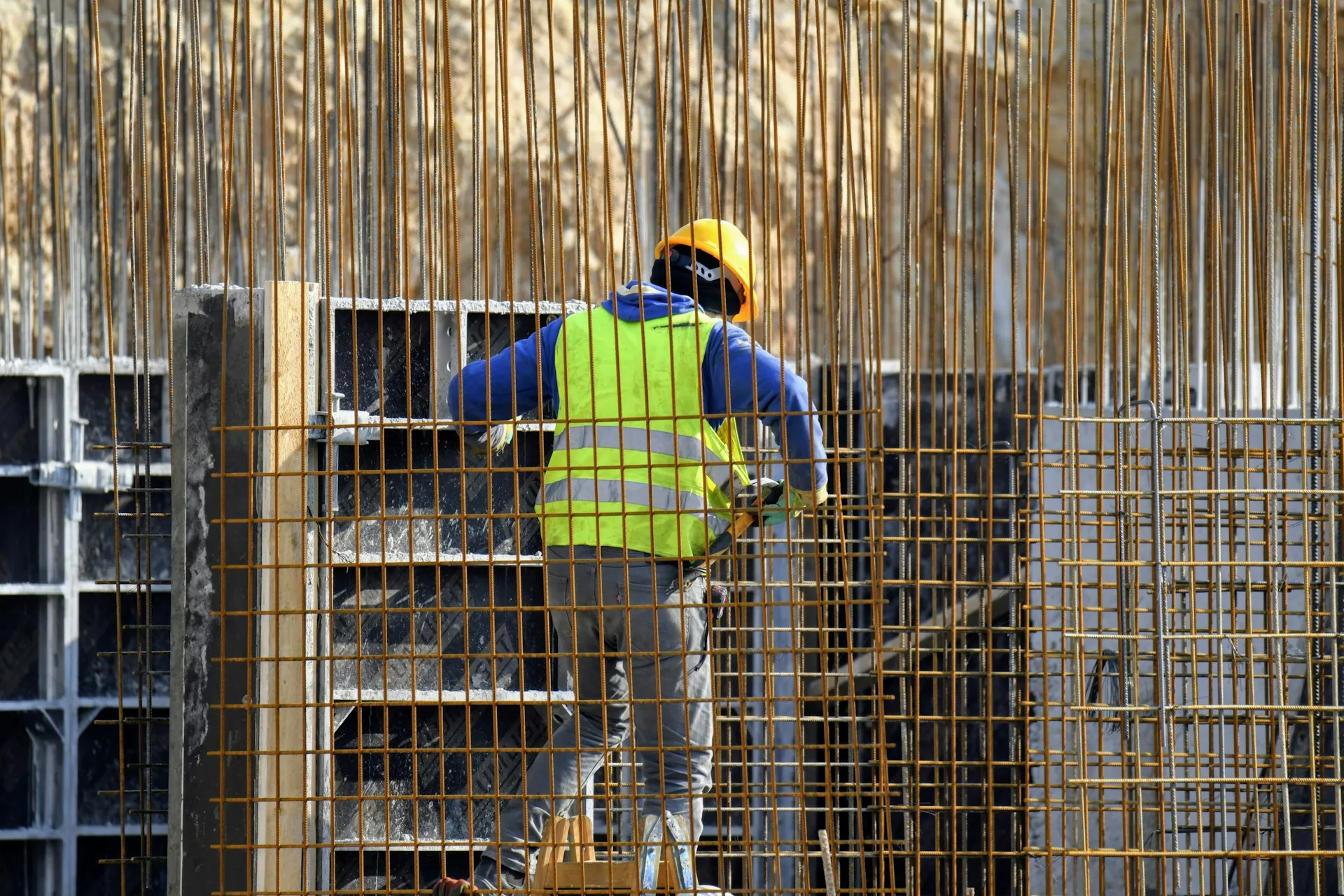 Construction worker in high-visibility clothing and hard hat on an active building site